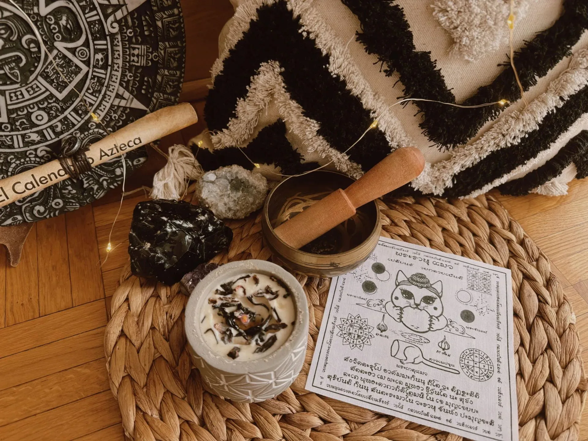 Objets chamaniques posés sur tapis tressé — calendrier aztèque, bol à fumigation, plantes